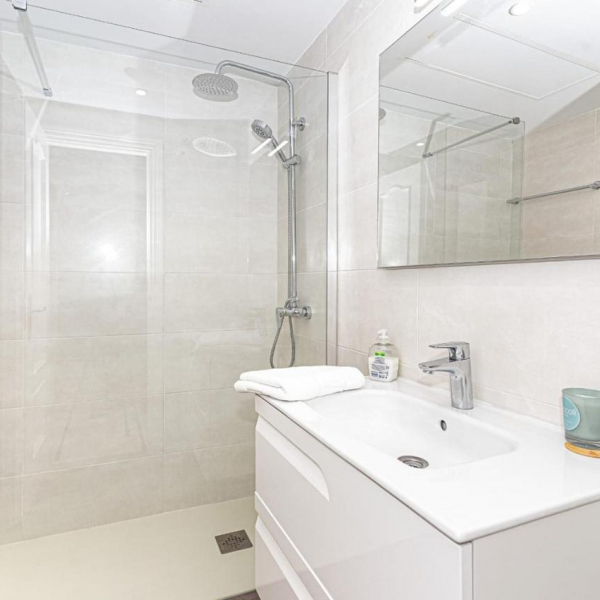 The bathroom with shower and washbasin