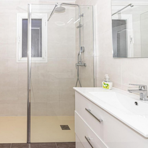 The bathroom with shower and washbasin